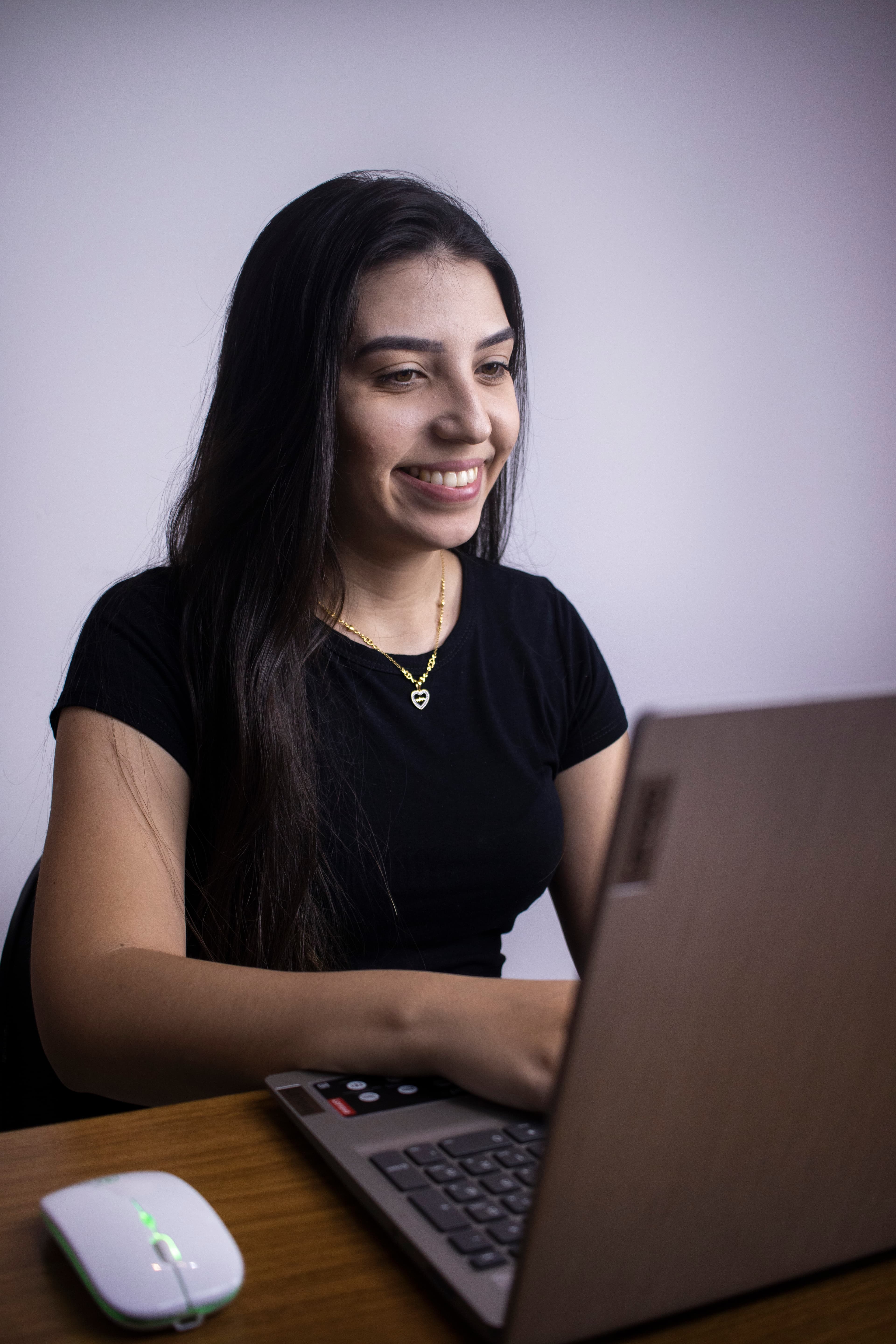 imagem de um funcionário da organiza mexendo em um notebook e sorrindo